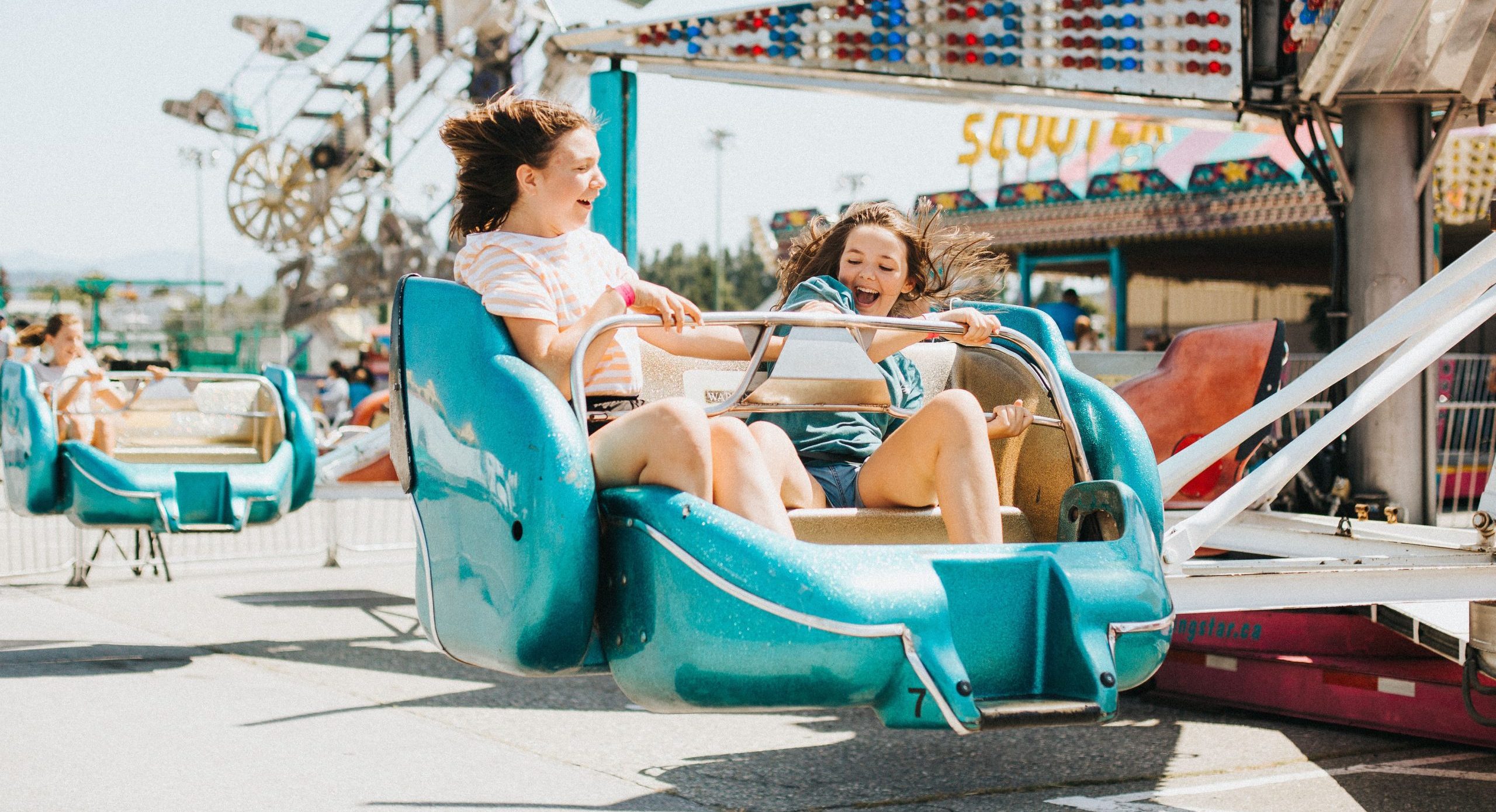 2 young girls riding an amusement park ride
